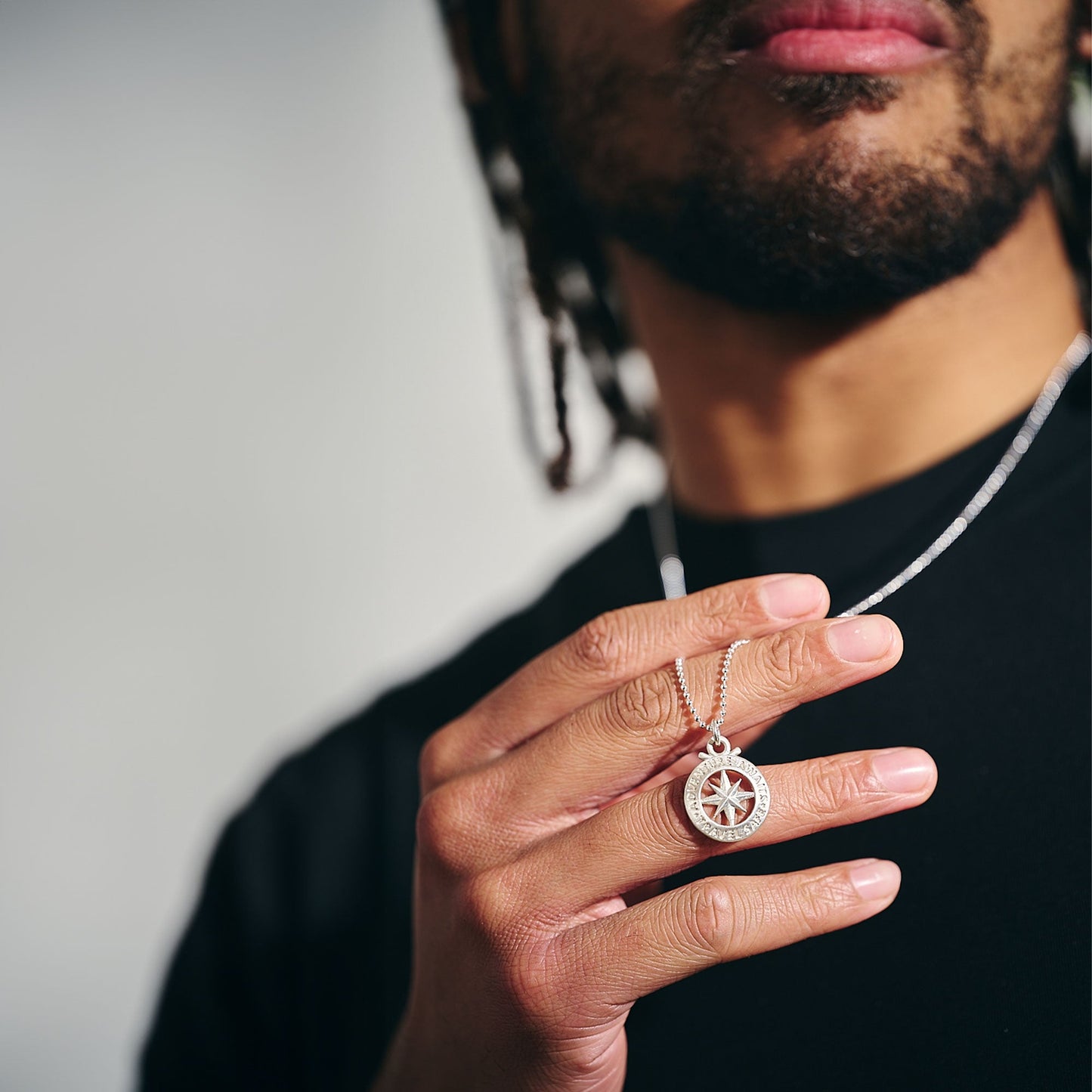 Large silver necklace featuring an outline compass and St Christopher icon by Scarlett Jewellery.