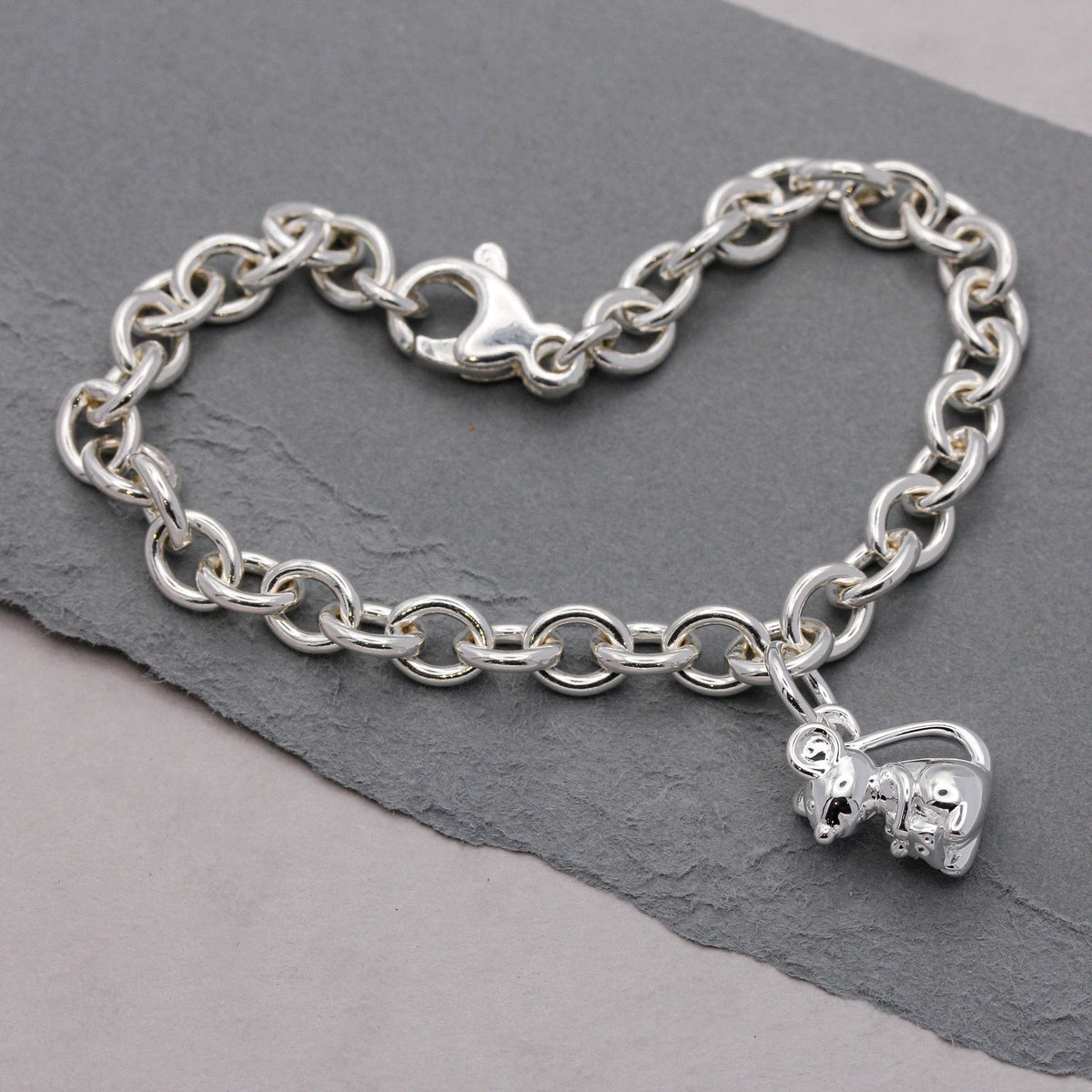 Silver mouse charm with detailed texture, displayed on a soft background, by Scarlett Jewellery.