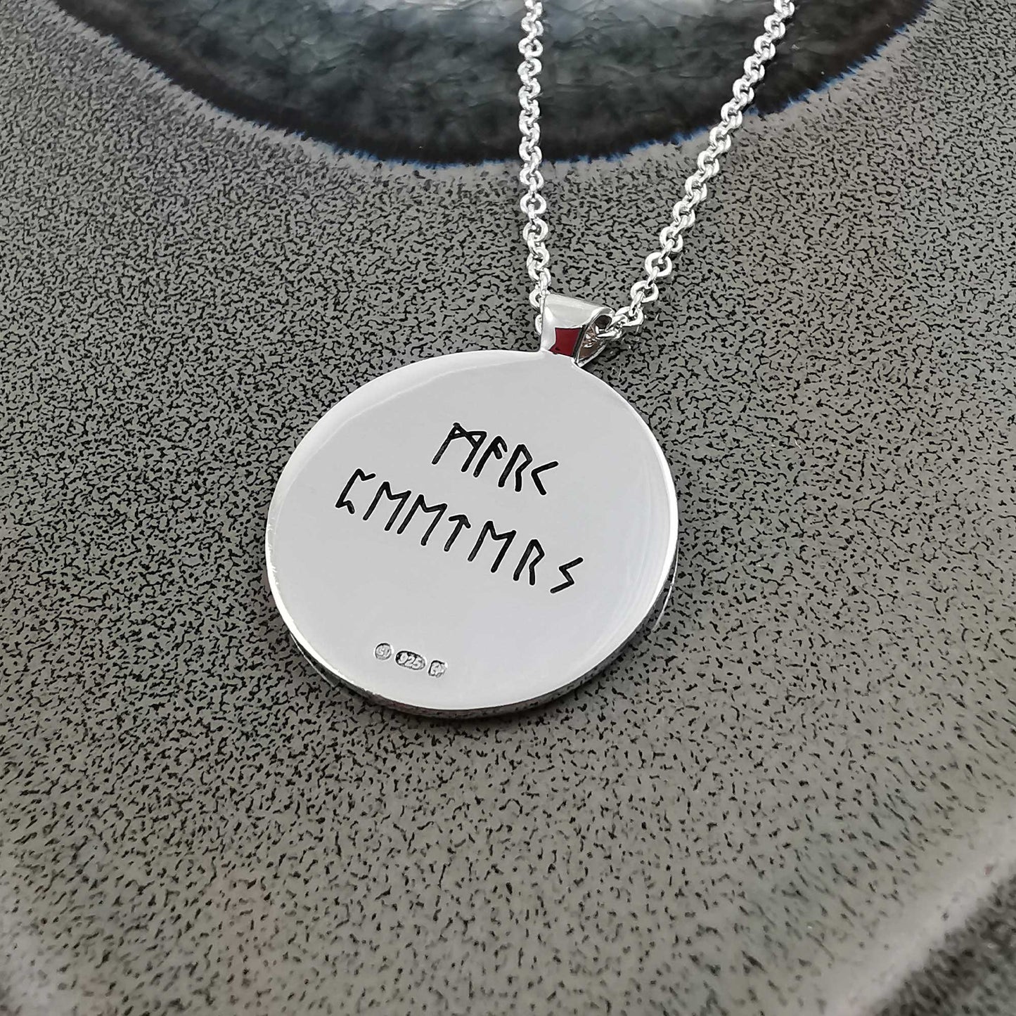 Silver Viking rune necklace with personalized engraving, shown close-up against a dark background by Scarlett Jewellery.