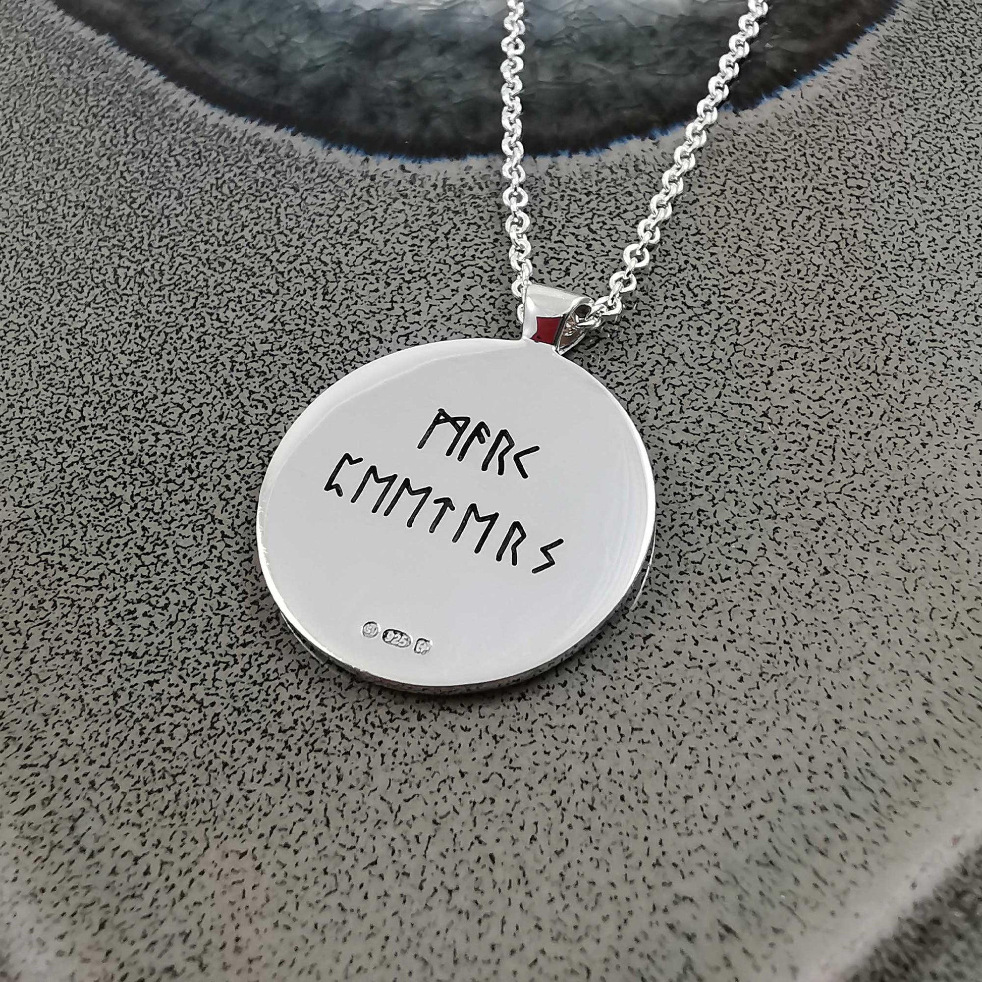 Silver Viking rune necklace with personalized engraving, shown close-up against a dark background by Scarlett Jewellery.