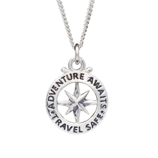 A large silver necklace featuring an outline compass and the name St Christopher, displayed against a dark background by Scar