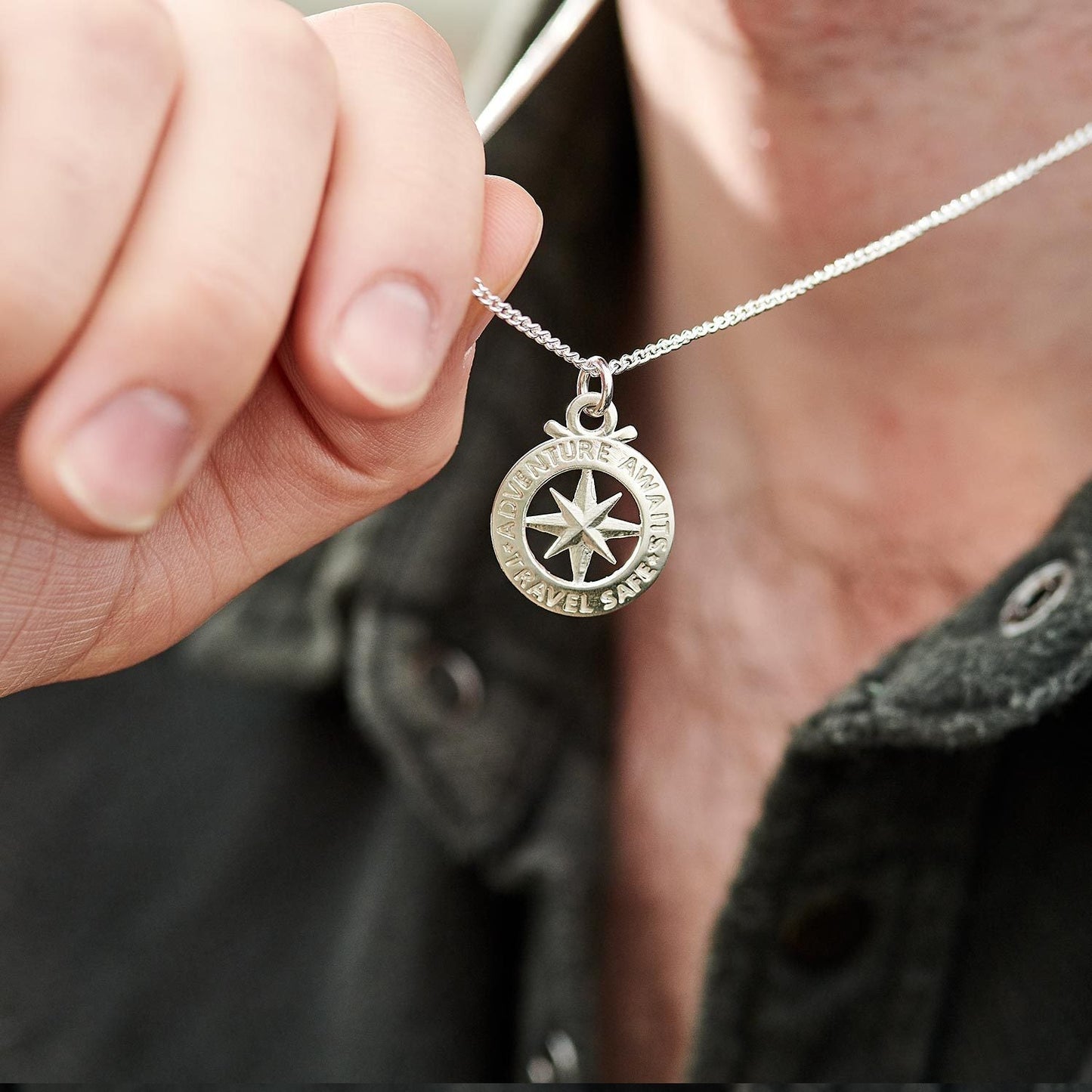 A large silver necklace featuring a detailed compass outline and the word "St Christopher" by Scarlett Jewellery.