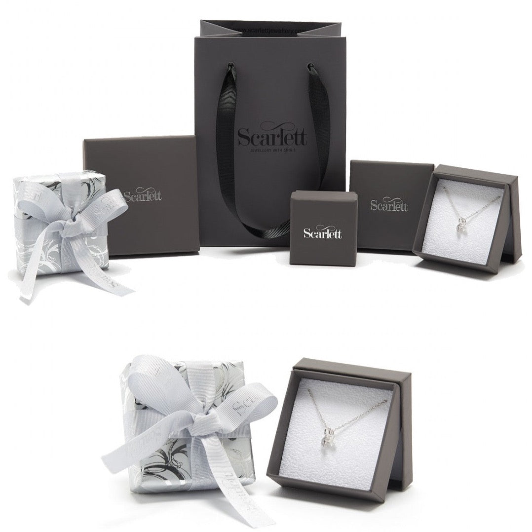 Silver forget-me-not flower charm with personalized engraving, displayed on a velvet background by Scarlett Jewellery.