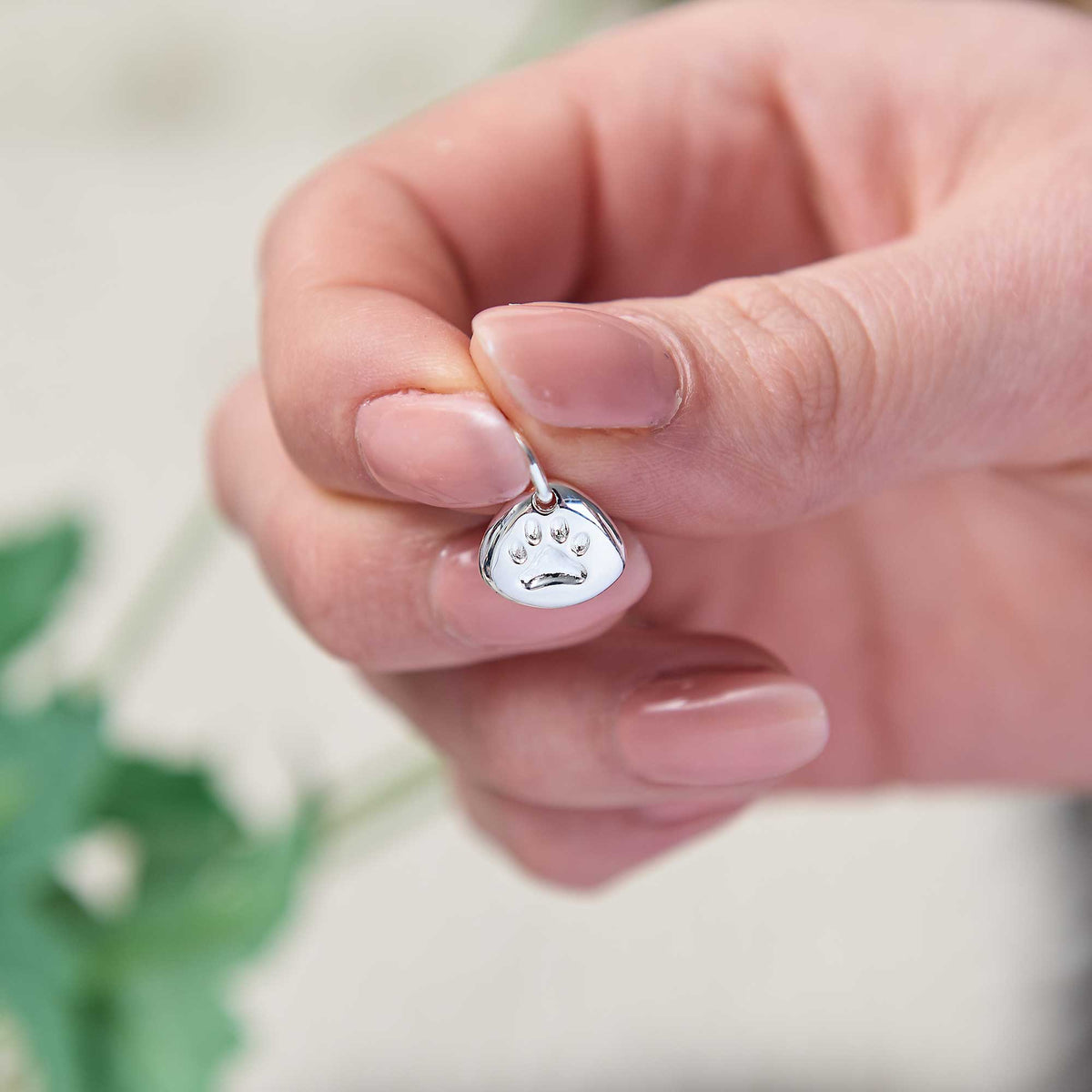 Silver pet paw print charm with personalized engraving by Scarlett Jewellery.