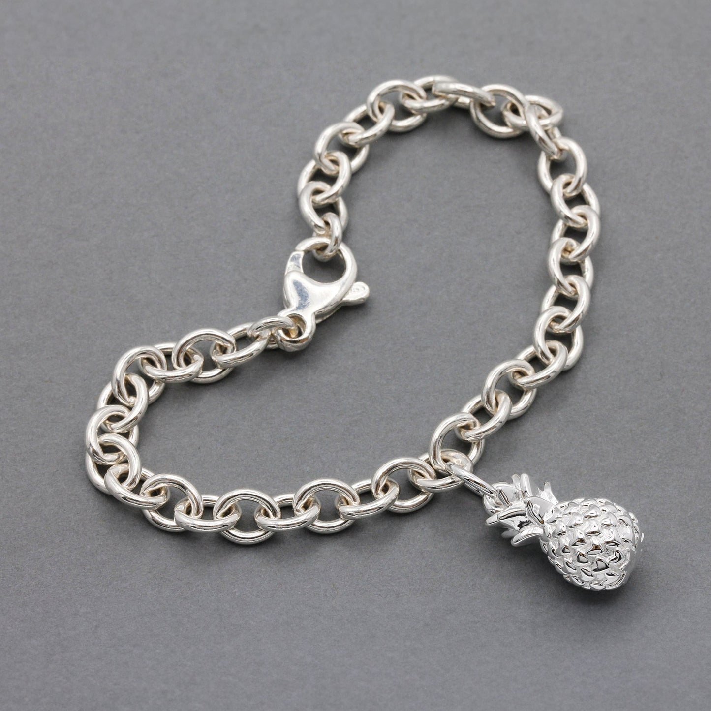 Silver pineapple charm with detailed texture, shown against a clean background, by Scarlett Jewellery.