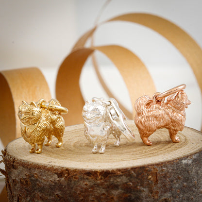 A silver Pomeranian dog charm shaped like a tiny puppy, detailed with realistic features, by Scarlett Jewellery.