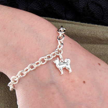A silver pomsky dog charm hangs on a chain, detailed with realistic fur texture and expressive eyes by Scarlett Jewellery.
