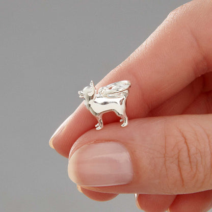 A silver pomsky dog charm with detailed facial features, displayed on a soft blue background by Scarlett Jewellery.