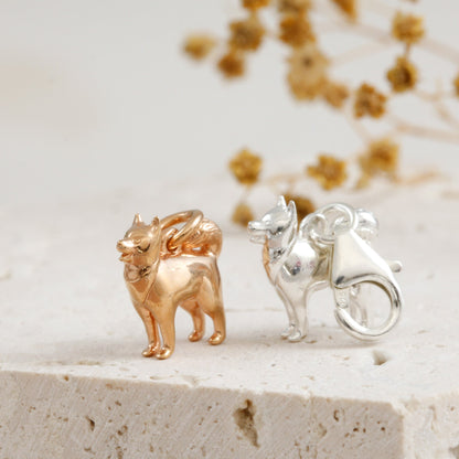 A silver pomsky dog charm hangs on a chain, detailed with realistic fur texture and expressive eyes by Scarlett Jewellery.