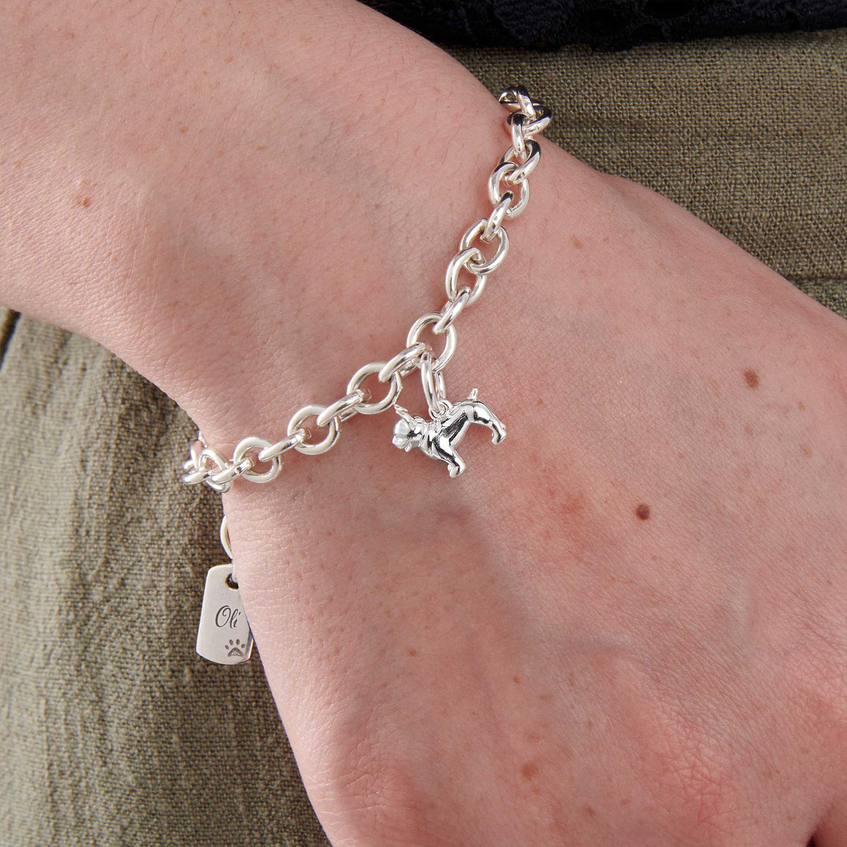 A silver pug dog charm bracelet by Scarlett Jewellery with a detailed paw print and chain design