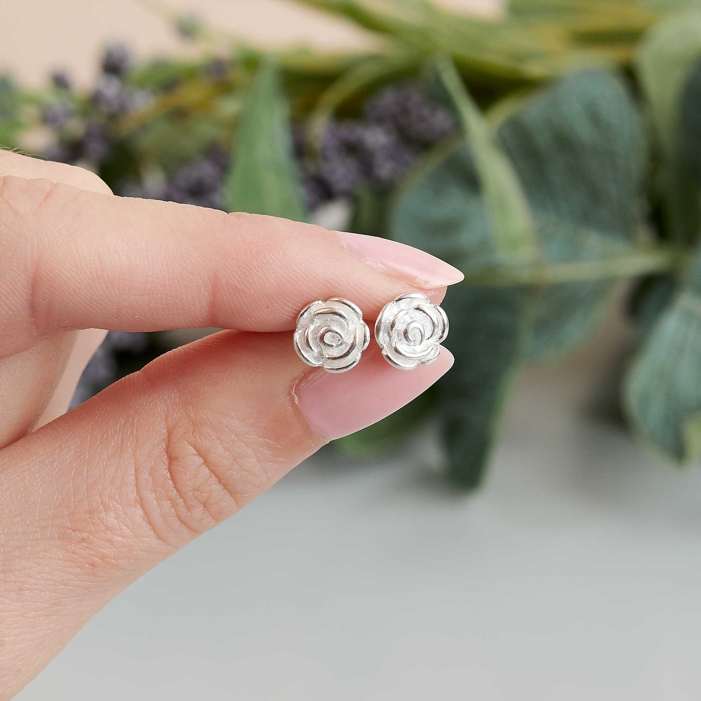 Silver stud earrings featuring a delicate rose flower design by Scarlett Jewellery.