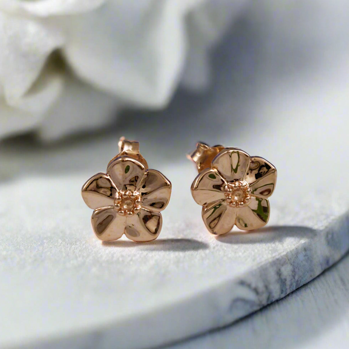 Small rose gold vermeil silver stud earrings with a delicate forget-me-not design by Scarlett Jewellery.