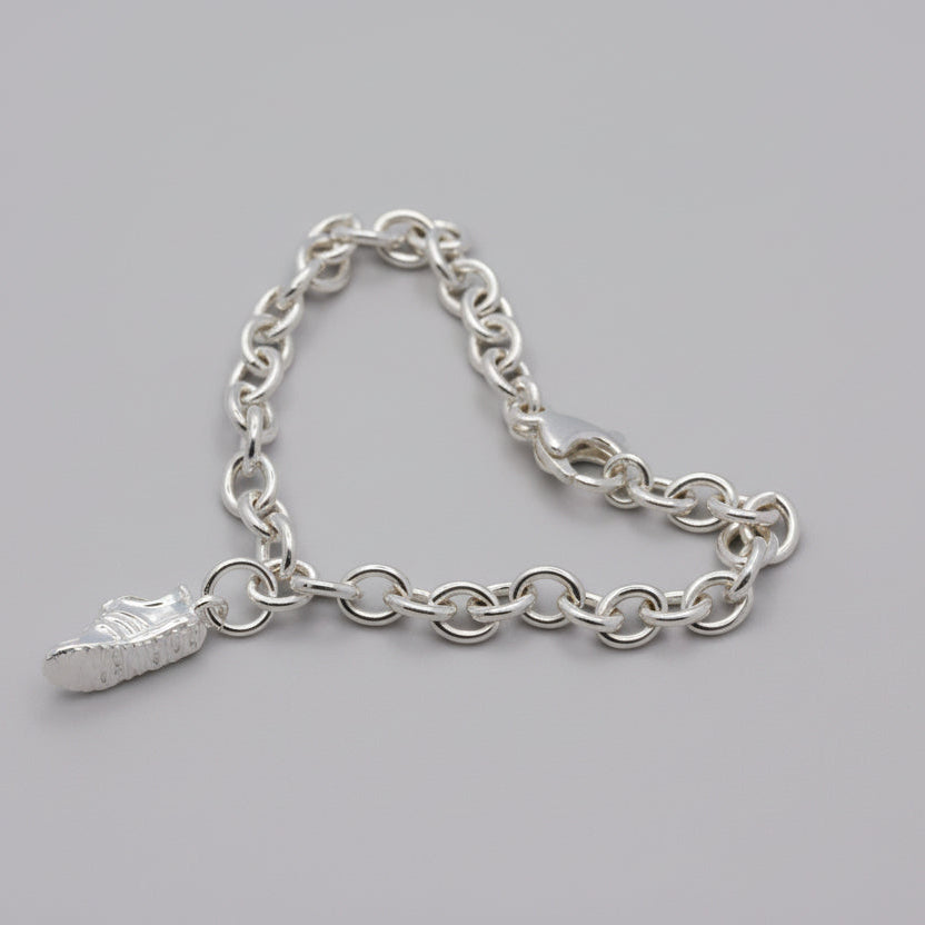 Silver charm with detailed etching on a running shoe by Scarlett Jewellery.