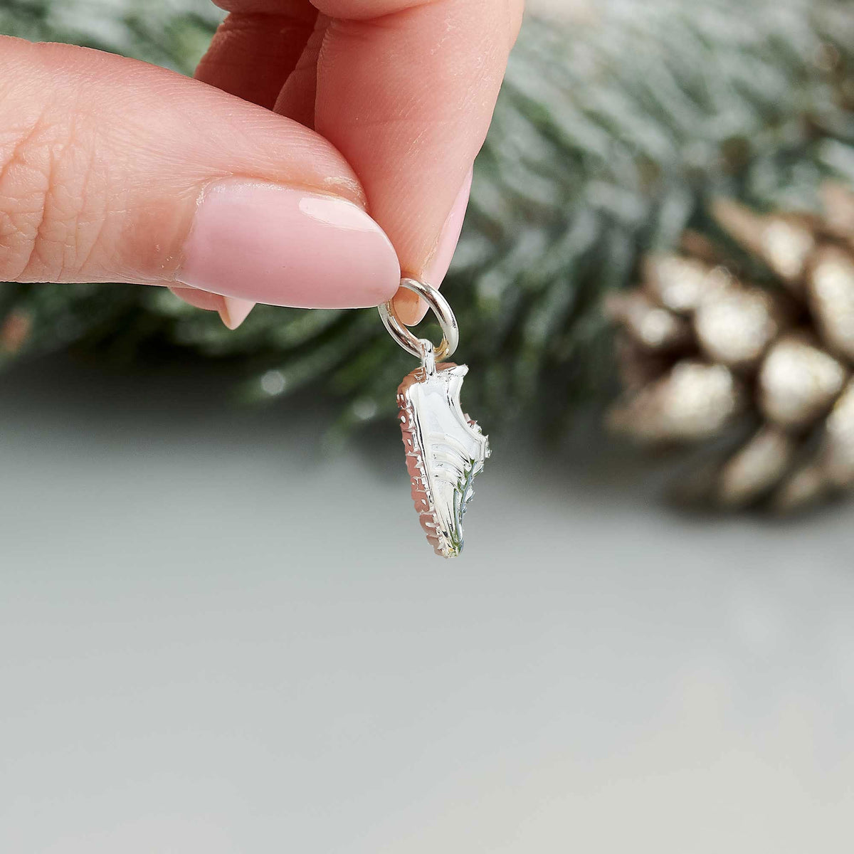 Silver charm with detailed etching on a running shoe by Scarlett Jewellery.