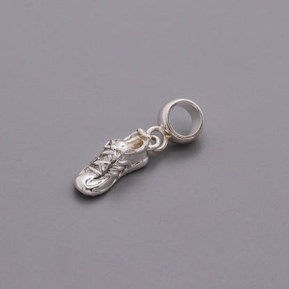 Detailed silver charm shaped like a running shoe, featuring laces and a shiny finish, from the Running Shoe Silver Charm by S