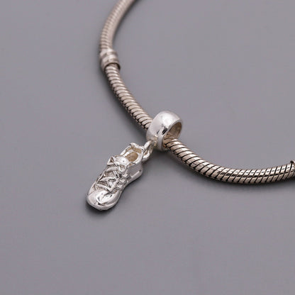 Silver charm with detailed etching on a running shoe by Scarlett Jewellery.
