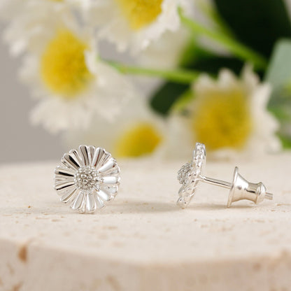 Small silver daisy earrings with detailed petals, styled on a white background by Scarlett Jewellery.