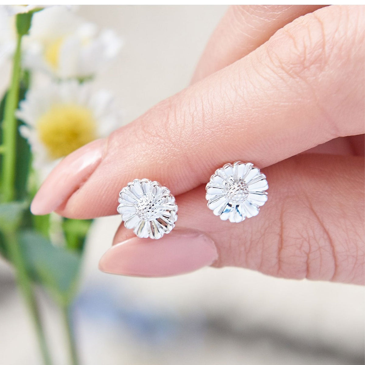 Daisy silver stud earrings with floral design, close-up view, by Scarlett Jewellery.
