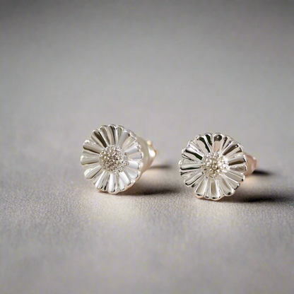 Small silver daisy earrings with detailed petals, styled on a white background by Scarlett Jewellery.