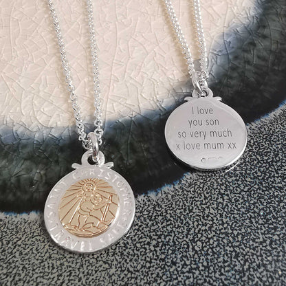 A silver and rose gold St Christopher necklace with personalized engraving, displayed on a soft background by Scarlett Jewell