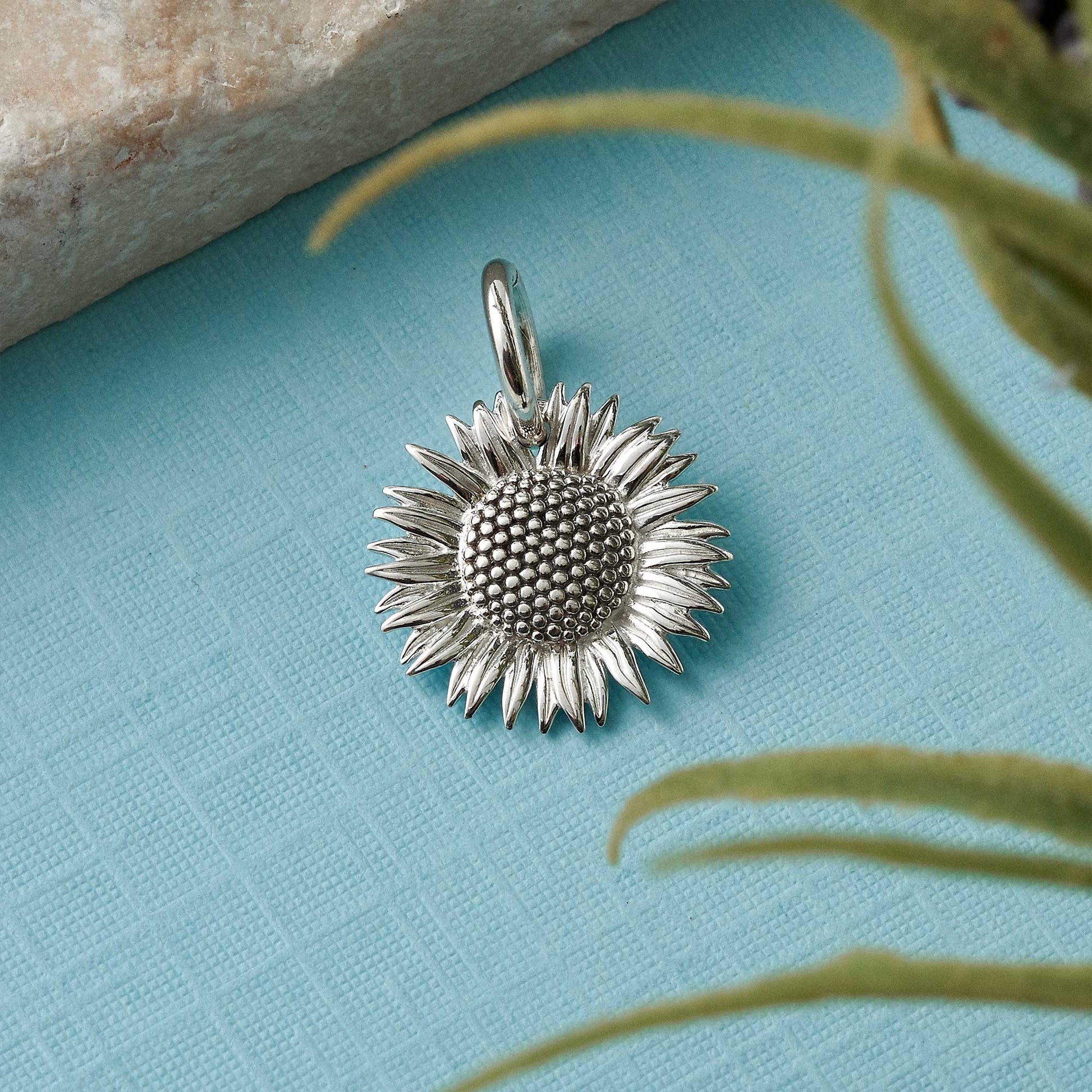 Sunflower silver charm with intricate details, styled on a necklace chain by Scarlett Jewellery.
