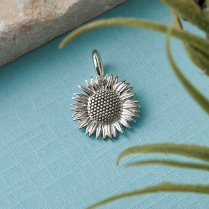 Sunflower silver charm with intricate details, styled on a necklace chain by Scarlett Jewellery.