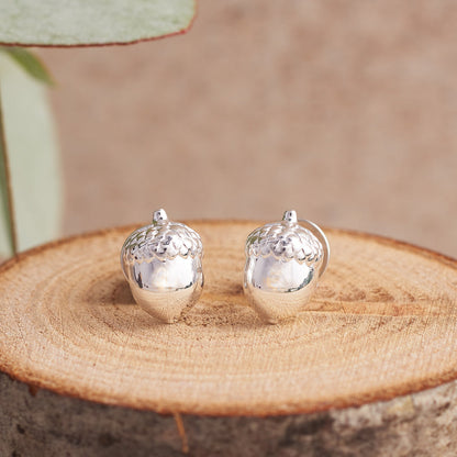 Silver acorn-shaped stud earrings with a polished finish, featuring a delicate design, by Scarlett Jewellery.
