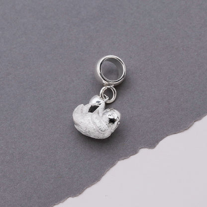A silver sloth charm shaped like a small hanging pendant by Scarlett Jewellery.