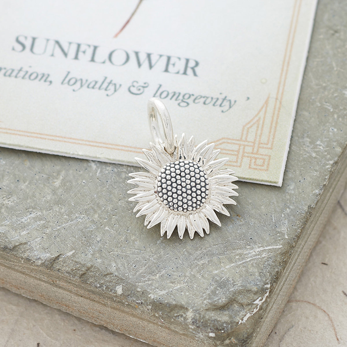 Sunflower silver charm with intricate details on a white background by Scarlett Jewellery.