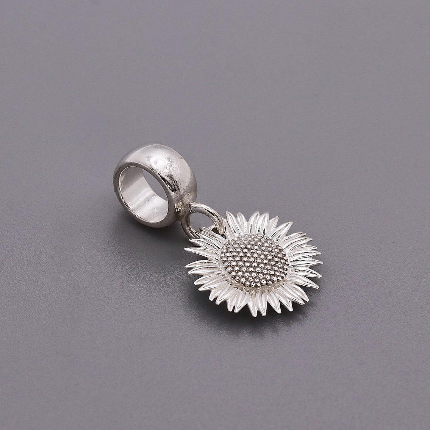Sunflower silver charm with intricate details on a white background by Scarlett Jewellery.