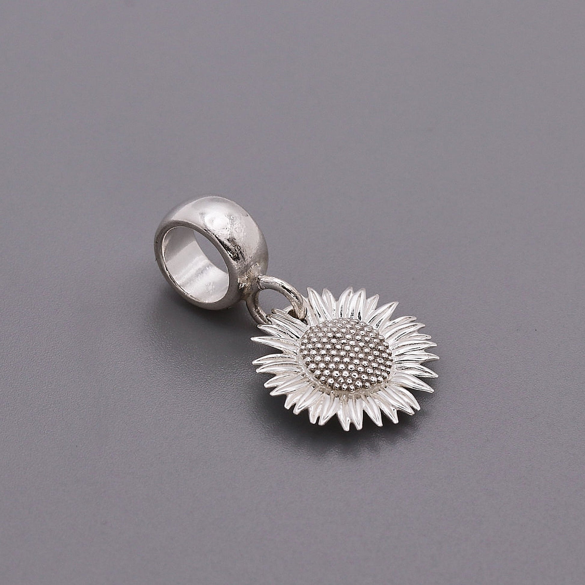 Sunflower silver charm with intricate details on a white background by Scarlett Jewellery.