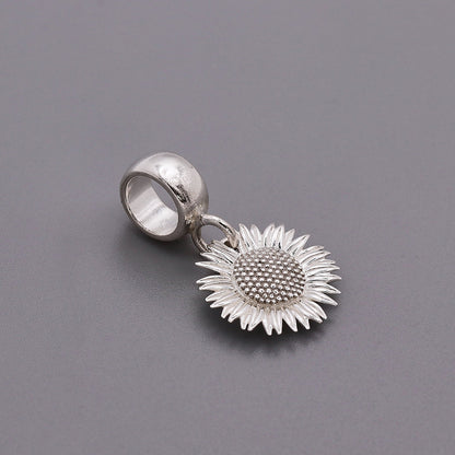 Sunflower silver charm with intricate details on a white background by Scarlett Jewellery.