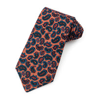 A mustard-colored silk tie featuring a paisley pattern and ancient madder dye, displayed horizontally with brand logo at the 