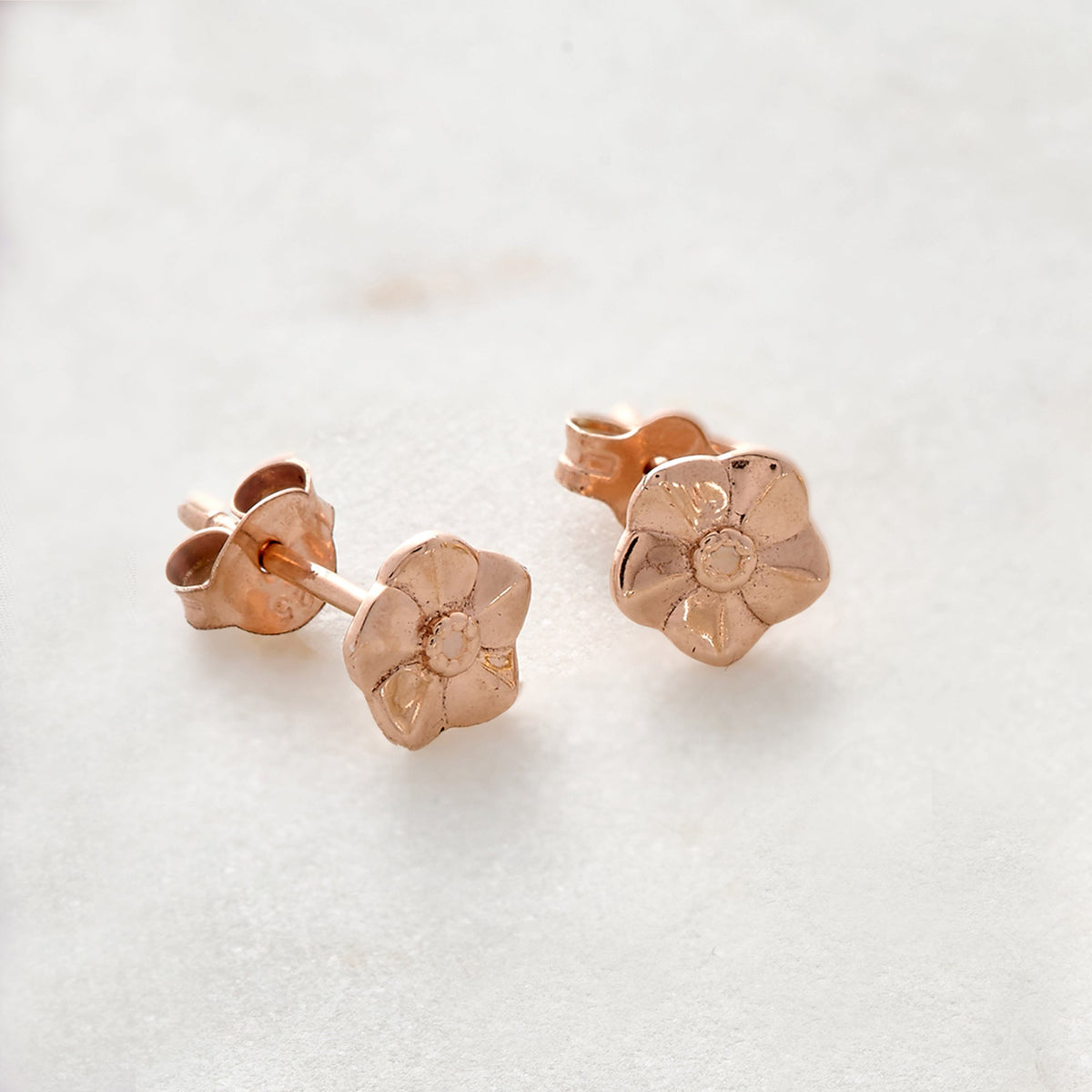 Tiny rose gold vermeil stud earrings with delicate forget-me-not design by Scarlett Jewellery.