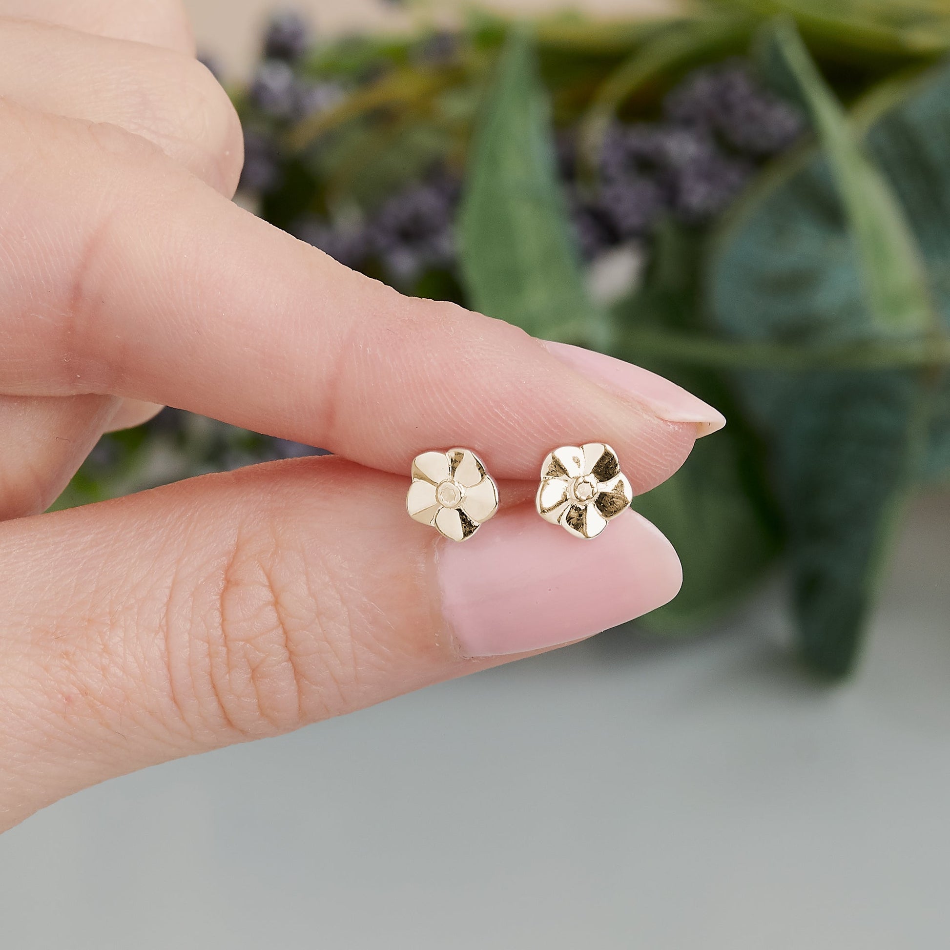 Tiny gold vermeil stud earrings with delicate floral details by Scarlett Jewellery.
