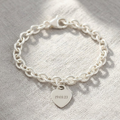 A silver heart tag charm bracelet with personalized engraving, featuring a delicate chain and tiny heart pendant by Scarlett 