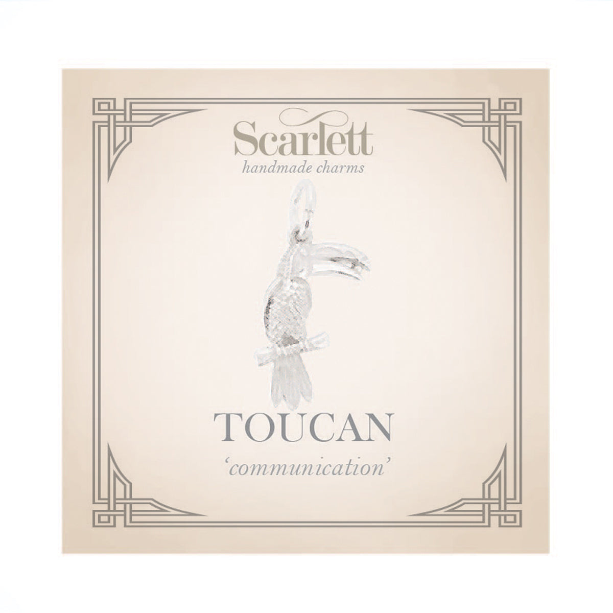 Silver toucan parrot charm with intricate detailing, displayed on a soft blue background, by Scarlett Jewellery.
