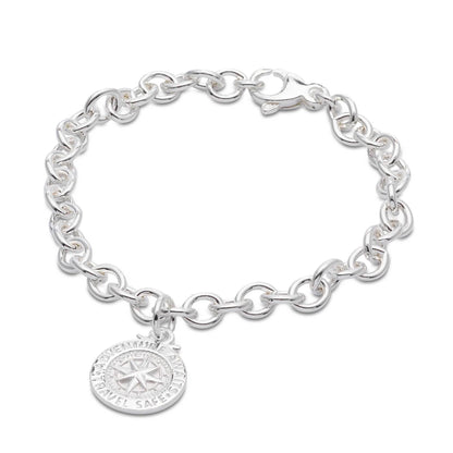 Silver compass charm with personalized engraving, styled on a travel-themed background by Scarlett Jewellery.