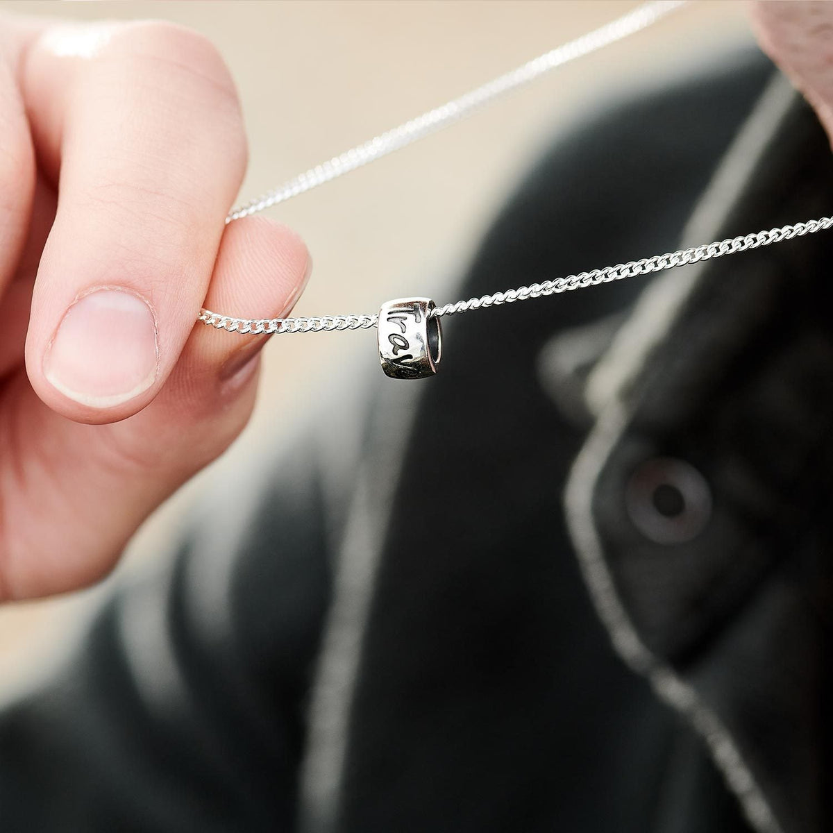 A silver recycled silver necklace with a minimalist design, displayed on a white background by Scarlett Jewellery.