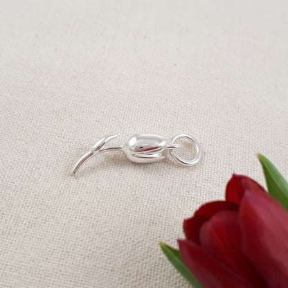 A silver tulip flower charm with intricate detailing, displayed on a soft white background, by Scarlett Jewellery.