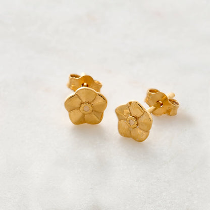 Tiny gold vermeil stud earrings with delicate floral details by Scarlett Jewellery.