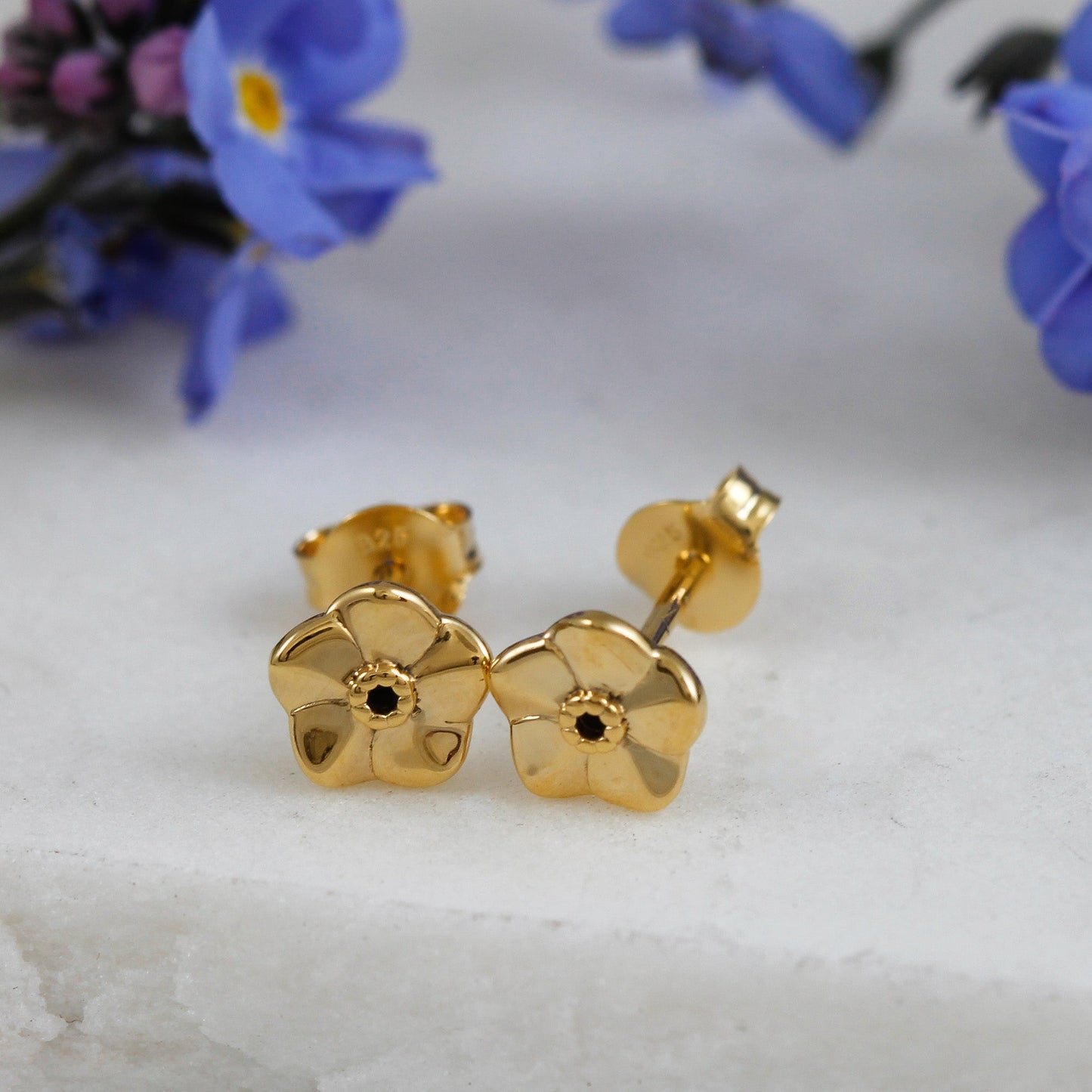 Tiny gold vermeil stud earrings with delicate floral details by Scarlett Jewellery.